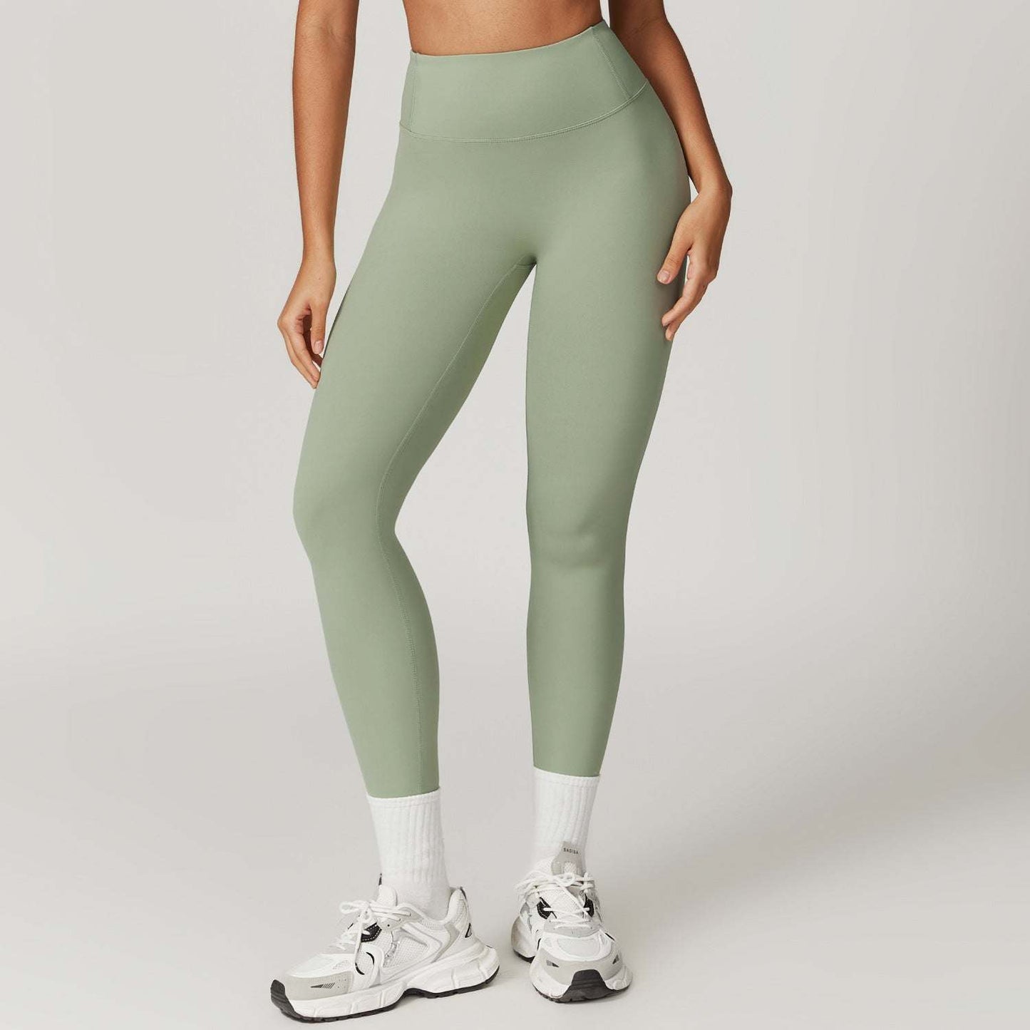 Woman wearing high-waist green leggings for yoga and gym workout