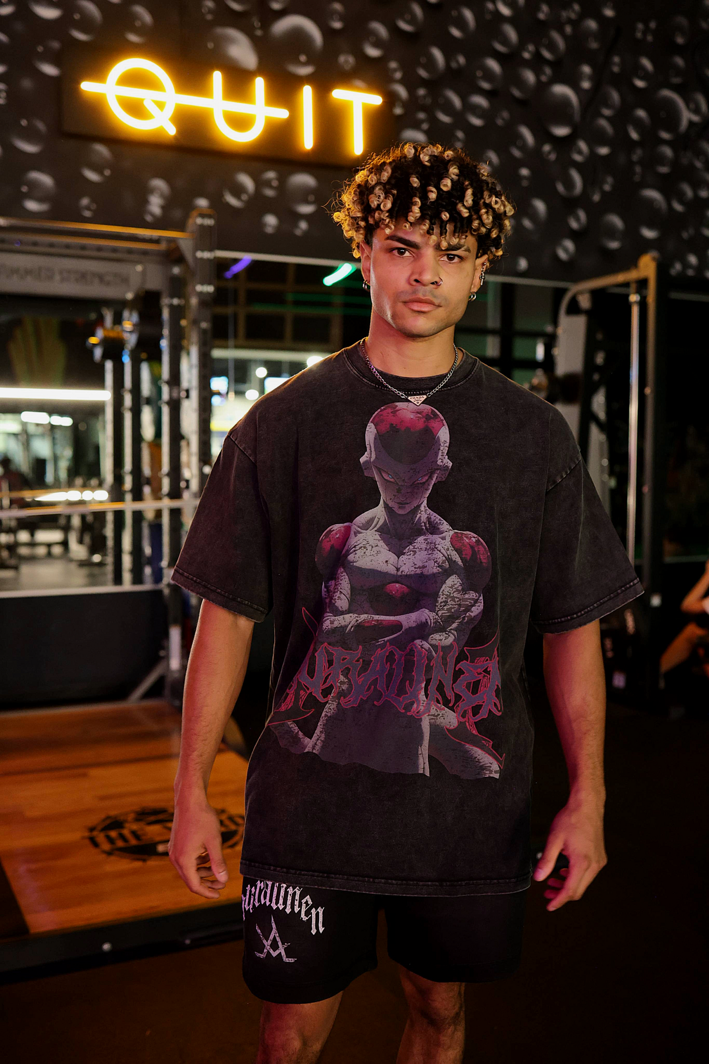 Young man wearing black Freeza Aura Tee with graphic print in gym setting