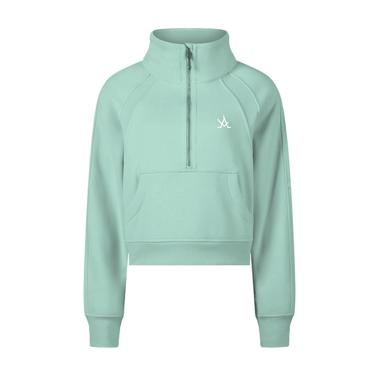 Define Cropped Jacket in light green with half-zip, hood, and long raglan sleeves, made from thick cotton-polyester blend.