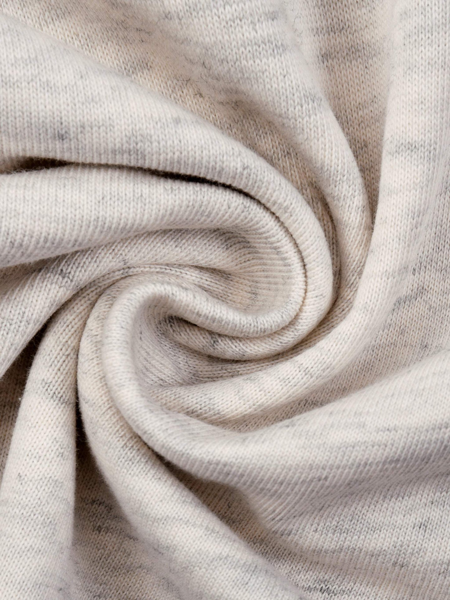 Close-up of soft cotton fabric of an Essential T-Shirt in light beige color with a loose knit pattern
